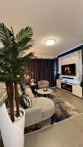 a living room with a couch and a palm tree at D&DLuxury Rivonia Apartments with inverter in Johannesburg