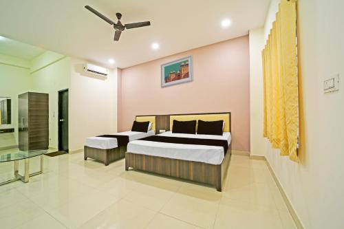 a bedroom with two beds and a ceiling fan at OYO Hotel Agrawal Inn in Bhopal