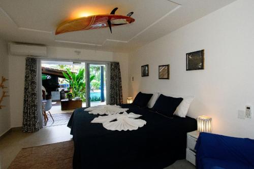 - une chambre avec un lit et une planche de surf dans l'établissement Aqui Bate a Brisa Pousada, à Arraial d'Ajuda