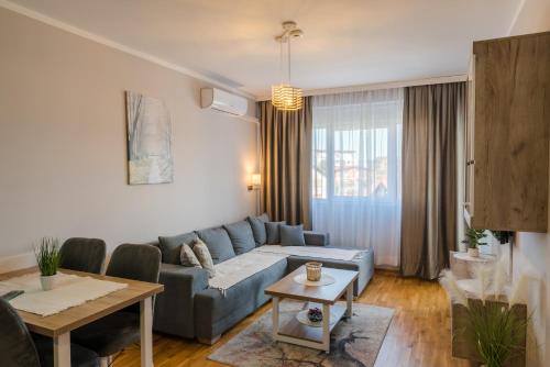 ein Wohnzimmer mit einem blauen Sofa und einem Tisch in der Unterkunft SPA 25 in Vrnjačka Banja