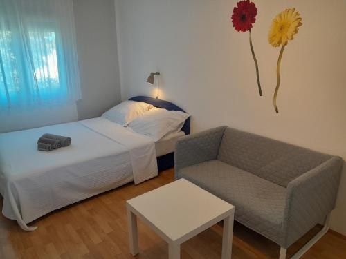 1 dormitorio con 1 cama, 1 sofá y 1 silla en Apartments Anchor with shared swimming pool, en Privlaka