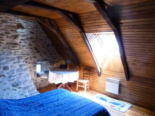 um quarto no sótão com uma cama e uma parede de pedra em Gîte de France à Sarroux - St Julien 3 épis - Gîte de France 8 personnes 134 em Sarroux
