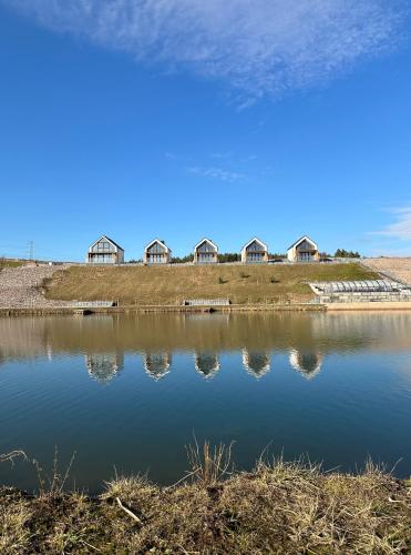 a large body of water with houses in the background at Biała Woda in Suwałki