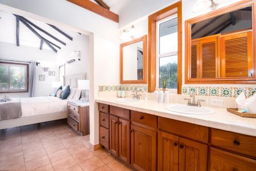 een badkamer met 2 wastafels en een slaapkamer met een bed bij Private Oceanfront 4-Bed Villa wPool on Huge Lot in Seine Bight Village