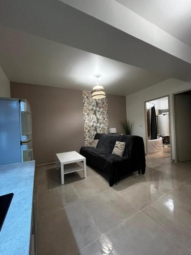 sala de estar con sofá negro y mesa en Appartement des Carmes en Nimes
