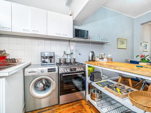 a kitchen with a stove and a washer at Cosy Victorian Style Full Apartment in Cape Town