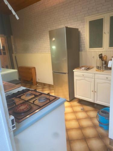 a kitchen with a stove and a stainless steel refrigerator at Maison à 10 m de la mer hyper centre in Les Sables-d'Olonne