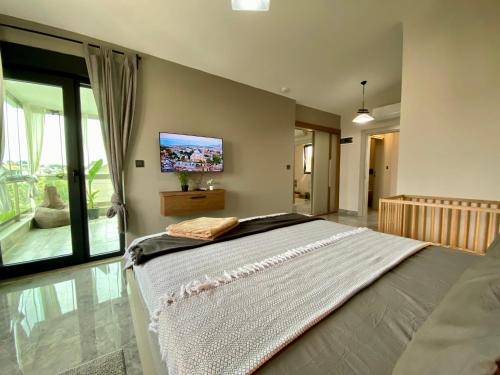 a bedroom with a large bed with a tv on the wall at Villa Annabèll1 with Swimming pool and Jacuzzi, 3 floors in Belek