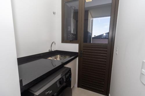 a bathroom with a sink and a mirror at Recanto dos Girassóis 206 - Excelente apartamento 2 quartos em prédio com piscina - à 200m do mar - (Consultar serviços de roupa de cama e banho) in Bombas