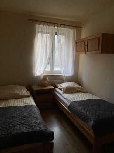 two beds in a room with a window at Hnatowe Berdo BB in Wetlina
