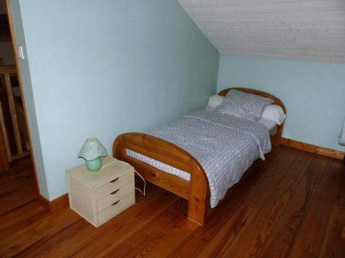 a bedroom with a bed and a night stand with a lamp at Gîte de France Le puy de diane (le dignou) 3 épis - Gîte de France 5 personn 574 