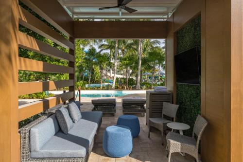 a patio with chairs and a tv and a pool at Hyatt Regency Coconut Point Resort & Spa Near Naples in Bonita Springs