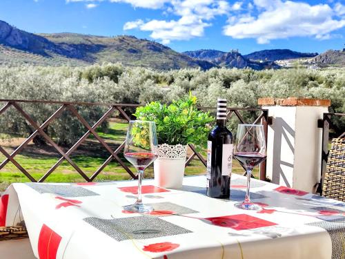 een tafel met een fles wijn en twee glazen bij Apartamento Rural Villa Aurora in Luque