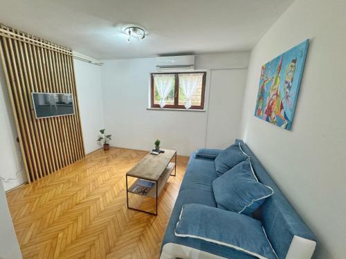 a living room with a blue couch and a table at Cute & Cosy Apartment Emi in Koper