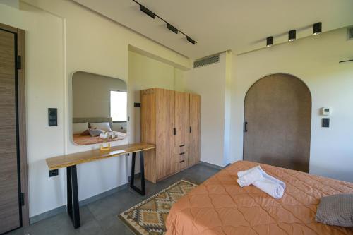 a bedroom with a bed and a desk and a mirror at Antinea Olympian Villa in Olympia