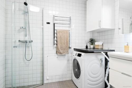 y baño blanco con lavadora. en Warm, cosy place to live en Gotemburgo