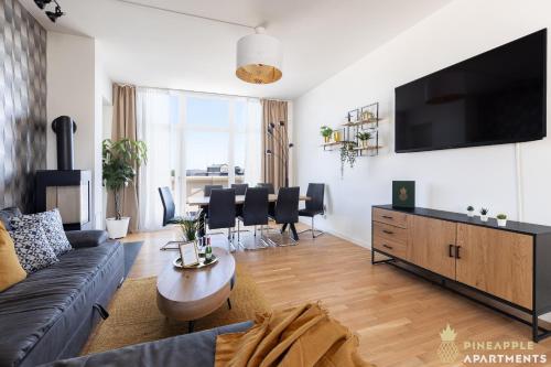 a living room with a couch and a tv at Pineapple Apartments Penthouse am Zwinger - 162 qm - 1x free parking in Dresden