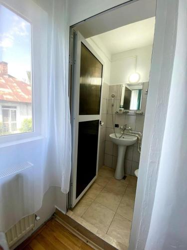 a bathroom with a sink and a toilet and a window at VILA SIXTY-NINE in Eforie Sud