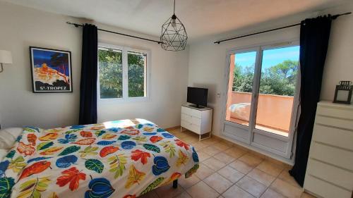 une chambre avec un lit, une télévision et une fenêtre dans l'établissement Villa La Folie Provencale, à Lorgues
