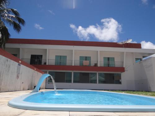 a swimming pool in front of a building at Hotel Vilas in Salinópolis