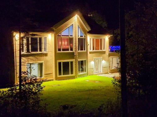 a house with a lit up yard at night at Chalet au Boisé in Saint Come