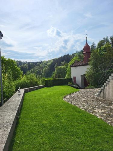 a person riding a bike in a grassy yard with a building at Zimmer-B&B Restaurant Wirtshaus zur Trostburg in Teufenthal