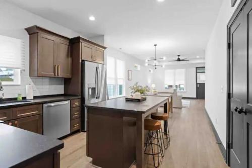 a kitchen with wooden cabinets and a large island with bar stools at Downtown Chattanooga that Sleeps 8 with a Pool Table in Chattanooga