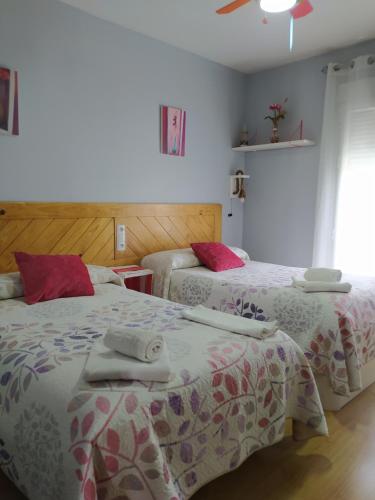 una camera con due letti con lenzuola rosa e bianche di CASA TEO a Cazorla