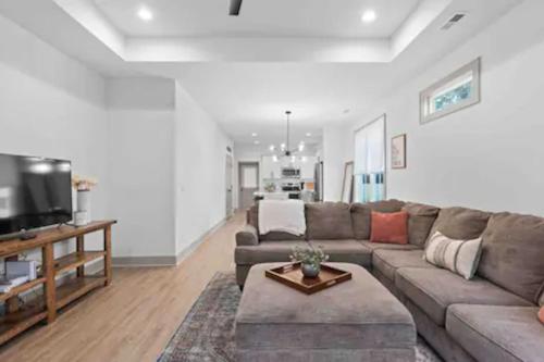 a living room with a couch and a flat screen tv at Discover Charm Cozy in the Heart of the City in Chattanooga