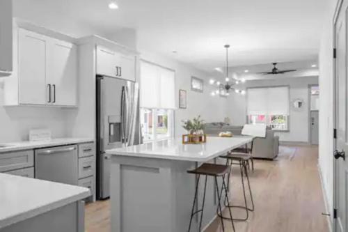 a kitchen with white cabinets and a kitchen island with bar stools at Discover Charm Cozy in the Heart of the City in Chattanooga