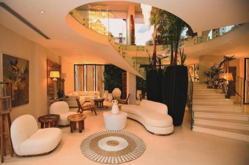 a living room with white furniture and a spiral staircase at Regina Blu in Vlorë