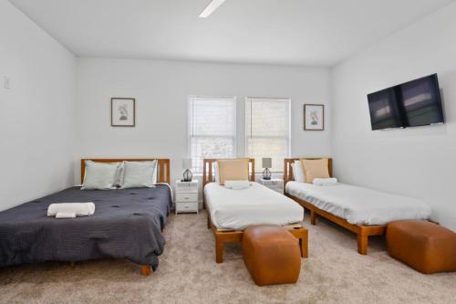 Habitación con 2 camas, 2 sillas y TV. en Perfect for large groups, en Indianápolis