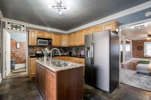 a kitchen with a stainless steel refrigerator and wooden cabinets at Entire Complex with 4 bedrooms and 9 beds in Kansas City