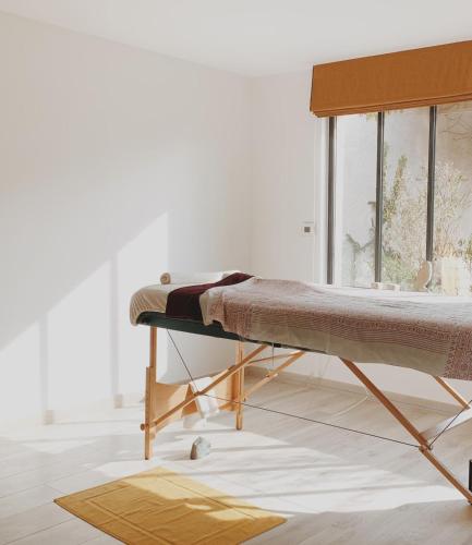 - un lit dans une chambre à côté d'une fenêtre dans l'établissement L'Atelier d'ici, à Thomery