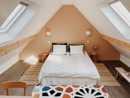 une chambre avec un lit dans un grenier dans l'établissement L'Atelier d'ici, à Thomery