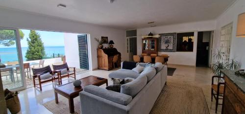 ein Wohnzimmer mit Sofa und Klavier in der Unterkunft Casa do Portinho in Portinho da Arrábida