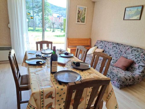 - une table à manger avec une bouteille de vin dans l'établissement T2 Centre Barcelonnette avec Garage, Terrasse et Parc Privé - FR-1-165A-101, à Barcelonnette