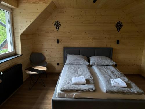 ein Schlafzimmer mit einem Bett in einem Holzzimmer in der Unterkunft Domek nad Dunajcem in Krościenko nad Dunajcem