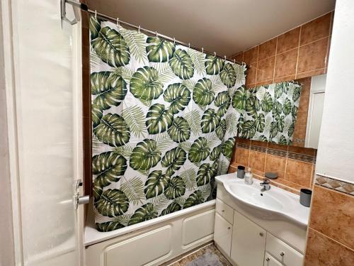 ein Bad mit einem Duschvorhang und einem Waschbecken in der Unterkunft Chelsea Studio Apartment - Sleeps 4 - near Cromwell Hospital in London