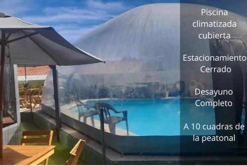 - Vistas a la piscina con sombrilla en Hotel Sebari en Villa Carlos Paz