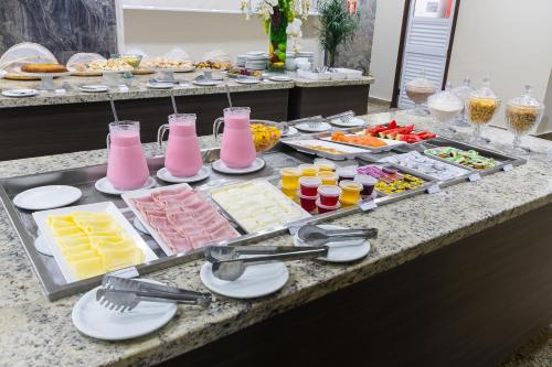 a buffet with many different types of food and drinks at Hotel Dan Inn Ribeirão Preto in Ribeirão Preto