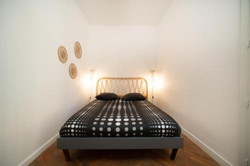 a black bed in a room with two clocks on the wall at Appartement tout équipe Vieux Port 4 couchages in Marseille