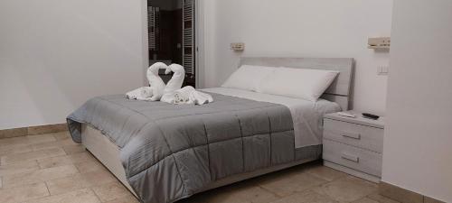 Un dormitorio con una cama con estatuas de cisnes. en l'aira ecchia - ospitalità rurale, en Lecce