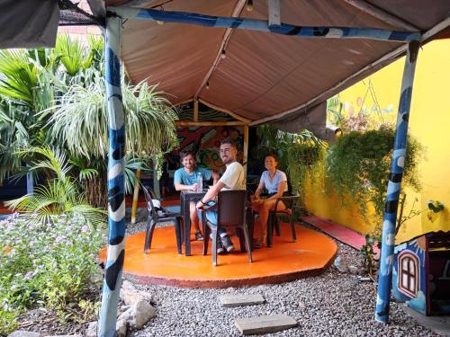 eine Gruppe von Personen, die an einem Tisch unter einem Zelt sitzen in der Unterkunft Casona Don Juan Hostel in San Gil