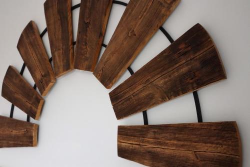 a wooden clock hanging on a wall at Busola House in Stegna