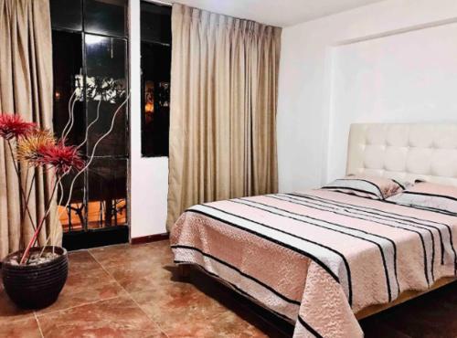 een slaapkamer met een groot bed en een raam bij Smart Apart Miraflores in Lima