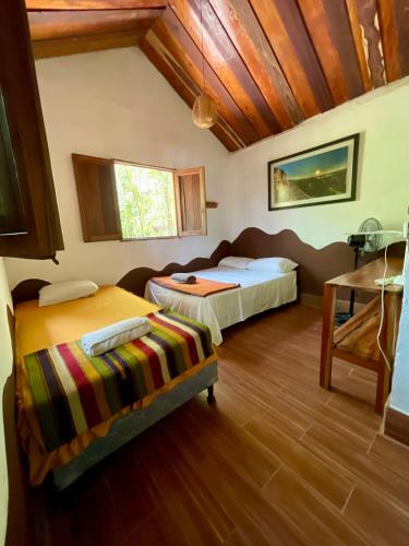 a bedroom with two beds and a wooden ceiling at Hotel Mon Ami in El Remate