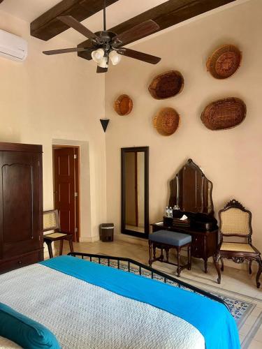 a bedroom with a bed and a piano at Hotel & Hostal Boutique Casa Garza in Mérida