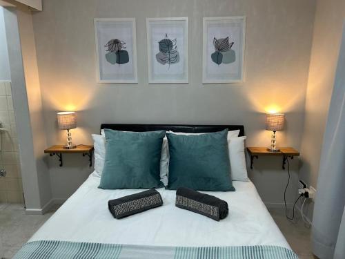 a bedroom with a bed with two pillows and two lamps at Addai Self Catering Brackenfell Durbanville area in Cape Town