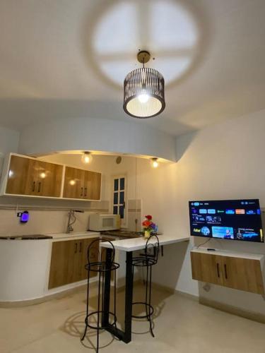 a kitchen with a table and some chairs and a light at Charme Bleue-Appartement Magique in Monastir